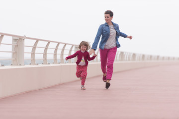 Fototapeta premium mother and cute little girl on the promenade by the sea