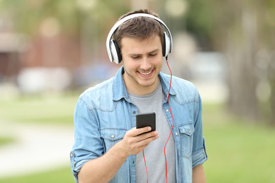 Teen boy walking and listening on line music