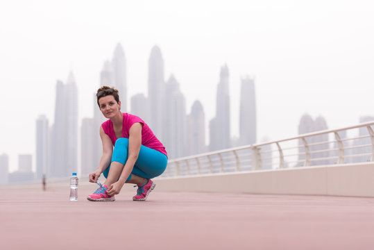 Woman Tying Shoelaces On Sneakers