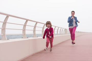 Obraz premium mother and cute little girl on the promenade by the sea