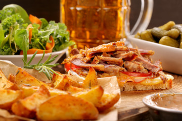 Sandwich with shredded pork, roasted potatoes and salad