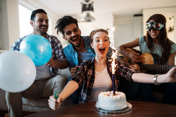 Cheerful young friends having fun on party