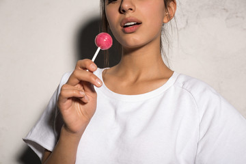 Cropped picture of young hipster woman holding candy.