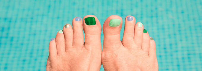 Close up on woman bare feet, blue water in the background, panorama © Delphotostock