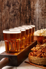 Beer row and snacks on wooden background football fan set