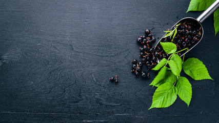 Fresh black currants on a wooden background. Top view. Free space.