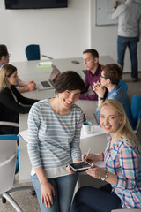 Pretty Businesswomen Using Tablet In Office Building during conference