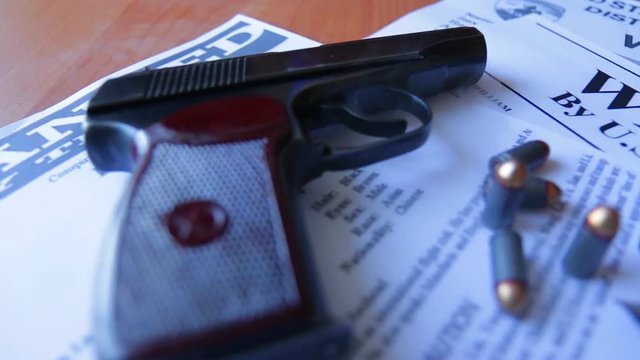 An announcement about the search for a criminal on the table of the bounty hunter, a combat pistol, cartridges