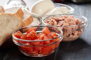 Ingredients ready for preparing bruschetta with tuna, mozzarella cheese and tomatoes