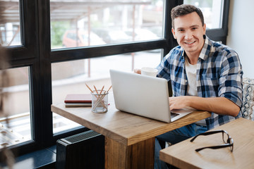 Fototapeta premium Handsome positive guy drinking coffee