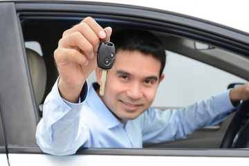 Smiling asian man as a driver showing car key