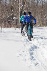 Attractive couple riding fat bikes in the snow