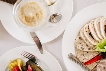 Тарелка с закуской из грибов, икры и мяса сыров на сервированном и накрытом столе в ресторане