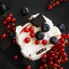 Ice cream with dark chocolate, blueberries and red currants on black background