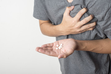 man with heart attack taking pill on white background