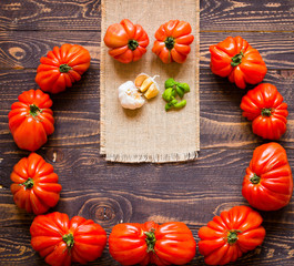 Ox heart tomatoes, on rustic wood background, free space for text.