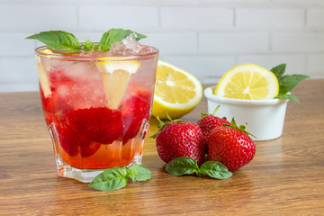 Glass of cold tea with mint,strawberry,lemon, on table