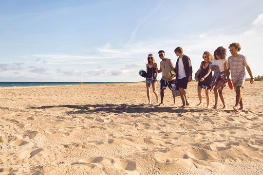 Multiracial group of friends walking at beach