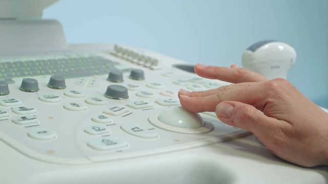Adult woman doctor's hand preparing an ultrasound device scan