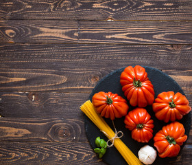 Ox heart tomatoes, on rustic wood background, free space for text.