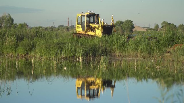 seagulls sitting on an abandoned bulldozer on the field of land reclamation