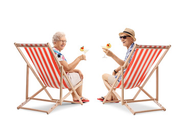 Elderly tourists with cocktails sitting in deck chairs