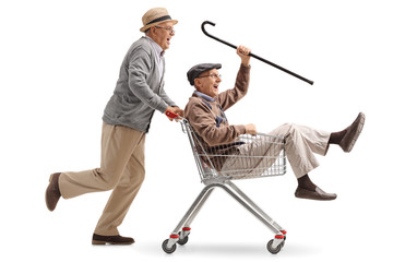 Senior pushing another senior in a shopping cart - obrazy, fototapety, plakaty