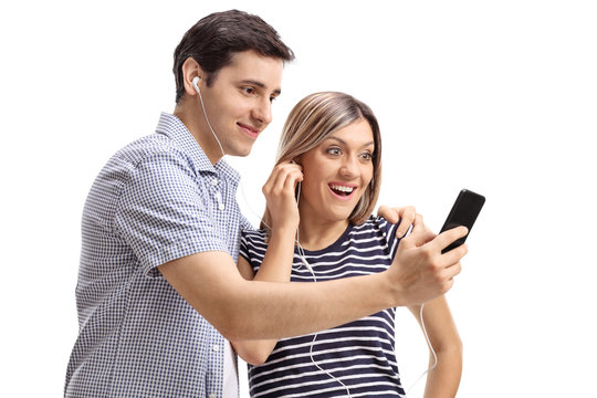 Young couple listening to music on a phone