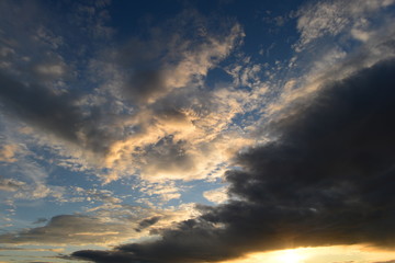 Sunlight in the sky from under the dark clouds at sunset