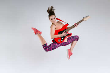 Happy girl with guitar in studio