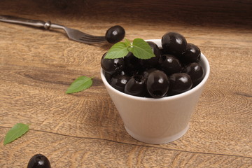 Black Olives on a Wood background