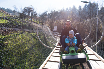 father and son enjoys driving on alpine coaster