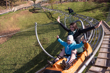 mother and son enjoys driving on alpine coaster