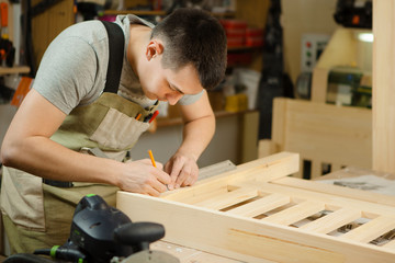 Craftsman measure distance between wooden planks with help of ruler.