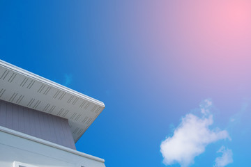 White eaves with ceiling and roof of modern house against blue sky.