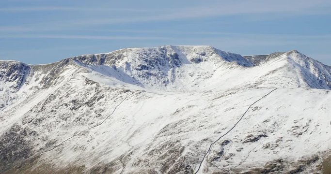 Winter views of snow covered mountains in the Eastern Fells of the English Lake District. Summits of Nethermost Pike, Helvellyn, Catstye Cam with mountain ridges of Striding Edge and Swirral Edge.