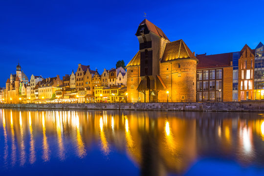 Historic port crane and ship over Motlawa river in Gdansk at night, Poland