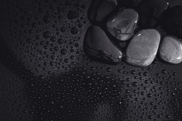 water rain drop with stones on shiny luxury black  for spa , relaxation and meditation  background concept
