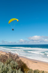 Paraglider above the ocean going towards the water in Australia