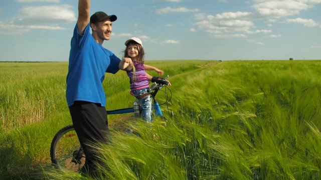 Family in nature. A man with a child on a bicycle.