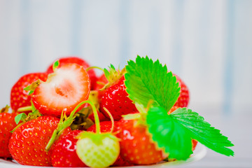 strawberries in bowl on wooden background with copy space and low key.