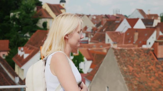 A female tourist admires the roofs of the old Eupropean city. Tourism in Europe