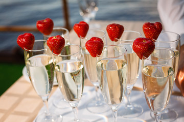 Obraz premium Waiter Standing With Champagne Glasses Next To Arranged Wedding Table