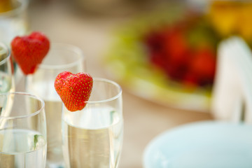 Waiter Standing With Champagne Glasses Next To Arranged Wedding Table