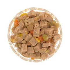 Glass bowl of lamb dog food isolated on a white background.