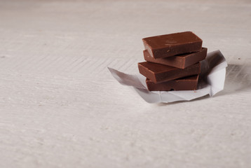 Broken milk chocolate on a white background,
