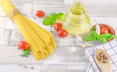 Italian spaghetti pasta and fresh ingredients on a rustic wooden background