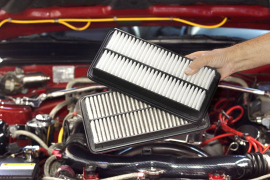 Mechanic changing air filter  in a car engine