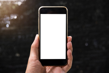 Business man holding smartphone with blank screen mobile with morning light.