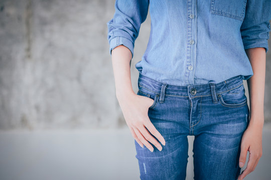 Closeup woman casual outfits standing and denims holds his hands in pockets. Concrete background with space for texture. woman beauty and fashion concept, Jeans concept